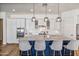 Bright kitchen with white cabinets, a contrasting blue island, stainless steel appliances and designer pendant lights at 22744 E Stonecrest Dr, Queen Creek, AZ 85142