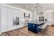 Kitchen featuring an oversized island with seating, white cabinets, stainless appliances, and modern lighting fixtures at 22744 E Stonecrest Dr, Queen Creek, AZ 85142