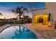Lakeside backyard features a swimming pool, covered patio with grill, and a relaxing view of the waterfront and palm trees at 2395 W Riverside St, Chandler, AZ 85248
