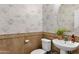 Stylish half-bath displaying decorative tile, a round mirror, and a pedestal sink at 2395 W Riverside St, Chandler, AZ 85248