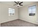 Bright bedroom featuring carpet, two windows, and a ceiling fan at 2395 W Riverside St, Chandler, AZ 85248