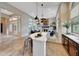 Open kitchen and living area featuring a white kitchen island, and a cozy fireplace at 29512 N 128Th Ln, Peoria, AZ 85383