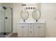Bathroom with white double vanity, framed mirrors, and glass shower with black hardware and gray and white tile at 3021 N Randolph Rd, Phoenix, AZ 85014