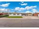 Charming single-story home with manicured front lawn and covered parking under a bright blue, partly cloudy sky at 3021 N Randolph Rd, Phoenix, AZ 85014