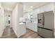 View into this all-white kitchen with modern appliances, quartz counters and stainless steel refrigerator at 3021 N Randolph Rd, Phoenix, AZ 85014