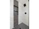 Close up of shower with black fixtures, mosaic flooring, and gray and white tile surround and recessed shelves at 3021 N Randolph Rd, Phoenix, AZ 85014