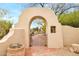 Gate with desert landscaping and an arched entryway to the property at 30600 N Pima Rd # 38, Scottsdale, AZ 85266