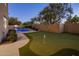 Expansive backyard with putting green, pool and mature trees perfect for entertaining and relaxation at 3737 E Donald Dr, Phoenix, AZ 85050