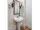 Elegant powder room with pedestal sink, stylish fixtures, and decorative wall sconces at 3737 E Donald Dr, Phoenix, AZ 85050