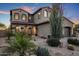 Elegant two-story home featuring a tiled roof and arched entryway, surrounded by desert landscaping at 3737 E Donald Dr, Phoenix, AZ 85050