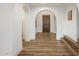 Bright hallway featuring arched doorways and wood floors at 3737 E Donald Dr, Phoenix, AZ 85050