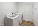 Convenient laundry room with modern washer and dryer, white cabinets, and laminate floors at 3737 E Donald Dr, Phoenix, AZ 85050