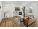 Bright living room features a cozy fireplace, wood floors, and ample natural light from large windows at 3737 E Donald Dr, Phoenix, AZ 85050