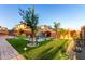 This low-maintenance backyard features artificial turf, mature landscaping, and a cozy fire pit seating area at 3739 S 180Th Dr, Goodyear, AZ 85338