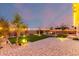 Relaxing backyard offers a fire pit, artificial turf, and ambient landscape lighting at 3739 S 180Th Dr, Goodyear, AZ 85338