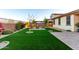 Well-maintained backyard features a fire pit area, lush artificial grass, and a paver patio for relaxing or entertaining guests at 3739 S 180Th Dr, Goodyear, AZ 85338