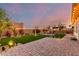 Beautifully landscaped backyard with a paver patio, fire pit, and lush artificial turf at 3739 S 180Th Dr, Goodyear, AZ 85338