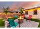 Backyard patio with a fire pit provides a cozy outdoor gathering space with landscape lighting at 3739 S 180Th Dr, Goodyear, AZ 85338