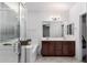 Bright bathroom with a double sink vanity, a glass-enclosed shower, and a luxurious bathtub at 3739 S 180Th Dr, Goodyear, AZ 85338