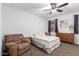 Cozy bedroom with a ceiling fan, comfortable armchair, and a window providing natural light at 3739 S 180Th Dr, Goodyear, AZ 85338
