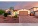 Charming single-story home featuring a brick driveway, manicured landscaping, and a two-car garage at 3739 S 180Th Dr, Goodyear, AZ 85338