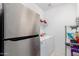 Well-lit laundry room with stainless steel refrigerator and washer/dryer set at 3739 S 180Th Dr, Goodyear, AZ 85338