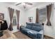 Cozy living room with a blue couch, neutral curtains, and a ceiling fan at 3739 S 180Th Dr, Goodyear, AZ 85338