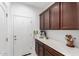 Pantry area with white countertop and dark wood cabinetry, next to an exterior door at 3739 S 180Th Dr, Goodyear, AZ 85338