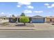 Inviting single-story home with a well-kept lawn, mature tree, and an attached two-car garage at 4055 E Catalina Cir, Mesa, AZ 85206