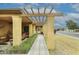 Inviting covered patio with a pergola and lush desert landscaping along the walkway at 416 Leisure World --, Mesa, AZ 85206