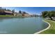 Beautiful waterfront homes line a pond with lush green landscape under a bright blue sky at 416 Leisure World --, Mesa, AZ 85206