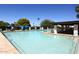 Relaxing community pool with lounge seating, umbrellas, and a covered area for shade on a clear day at 416 Leisure World --, Mesa, AZ 85206