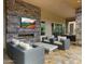 An inviting covered patio features a stone fireplace, comfortable seating, and a view of the landscape at 4611 E Casitas Del Rio Dr, Phoenix, AZ 85050