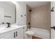 A modern bathroom features a sleek shower over tub, toilet, and a vanity with a large mirror at 4739 W Paradise Ln, Glendale, AZ 85306