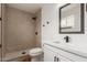 A modern bathroom features a sleek shower, toilet, and a vanity with a large mirror at 4739 W Paradise Ln, Glendale, AZ 85306