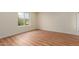 Bright bedroom featuring modern laminate flooring and a window letting in natural light at 4739 W Paradise Ln, Glendale, AZ 85306