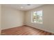 Sun-filled bedroom with wood-look flooring and a large window offering views of the neighborhood at 4739 W Paradise Ln, Glendale, AZ 85306