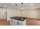 Kitchen island features a dark stone countertop, white cabinets, and modern pendant lighting at 4739 W Paradise Ln, Glendale, AZ 85306