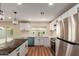 Renovated kitchen boasts stainless appliances, white cabinets, modern lighting, and a view to the backyard at 4739 W Paradise Ln, Glendale, AZ 85306
