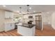 Renovated kitchen with stainless appliances, white cabinets, dark countertops, a kitchen island, and wood-look flooring at 4739 W Paradise Ln, Glendale, AZ 85306