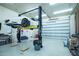 Well-lit garage featuring a vehicle lift and plenty of open space for projects and repairs at 5102 W Soft Wind Dr, Glendale, AZ 85310