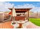 This backyard features a spa under a gazebo, outdoor kitchen, and wood-look decking at 535 E Yellow Wood Ave, San Tan Valley, AZ 85140