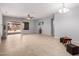 A spacious living room with neutral paint, tile flooring, and a sliding glass door to the patio at 535 E Yellow Wood Ave, San Tan Valley, AZ 85140
