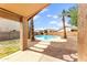 View of the backyard featuring a covered patio and pool surrounded by palm trees and desert landscaping at 6436 W Wahalla Ln, Glendale, AZ 85308