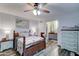 Cozy bedroom featuring a ceiling fan, wood-look floors, and an ensuite bathroom for added convenience at 6461 E Jensen St, Mesa, AZ 85205
