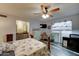 Cozy bedroom with a ceiling fan, wood-look floors, and ample natural light from a window at 6461 E Jensen St, Mesa, AZ 85205