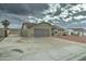 Spacious driveway leading to a two-car garage, complemented by desert landscaping and a secure side gate at 6461 E Jensen St, Mesa, AZ 85205