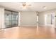 Bright living room featuring wood floors, ceiling fan, sliding glass doors to a patio, and neutral paint at 6900 E Princess Dr # 2124, Phoenix, AZ 85054