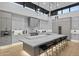 Modern kitchen with sleek cabinetry, stone countertops, an island with bar seating and modern pendant lights at 7009 E Pasadena Ave, Paradise Valley, AZ 85253