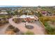 This aerial view captures the serene desert landscape, highlighting the home's red door and circular driveway at 706 N Signal Butte Rd, Mesa, AZ 85207